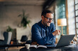 © bnenin - Smiling man having an online meeting, talking to his colleagues.