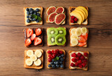 Fototapeta Zwierzęta - Tasty toasts with different spreads and fruits on wooden table, flat lay
