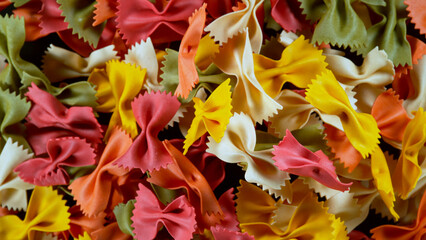 Freeze motion of flying uncooked italian pasta farfalle on black background