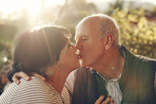 Kiss, Love And Senior Couple In Nature, Park Or Outdoor For Retirement Wellness, Care And Life Together In Summer Sunshine. Holiday, Travel And Elderly People With Countryside Date Or Anniversary