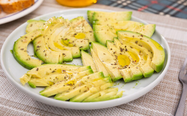 ripe avocado pulp cut into pieces sprinkled with lemon juice on a plate