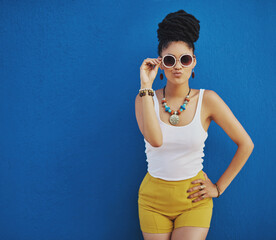 Poster - Fashion, summer and black woman with sunglasses on blue background wall in city on weekend. Freedom, beauty and girl enjoy holiday, travel and vacation in urban town with trendy clothes and cosmetics