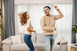 © dusanpetkovic1 - A playful couple is dancing in a living room in their new apartment.