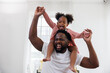 © Rattanachat - enjoy happy love black family african american father carrying daughter little african girl child smiling and having fun moments good time.  American father day concept.