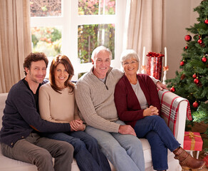 Canvas Print - Christmas, family and together on sofa for portrait in living room to celebrate festive holiday. Quality time, relax and happy family relax for bonding, support and care on couch for celebration