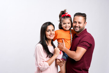 Wall Mural - Happy indian couple with her daughter standing on white background.