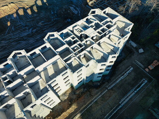 The initial stage of construction of a prefabricated reinforced concrete house. Assembly of a panel house. Shooting from a drone. Modern construction. Construction site close-up. View from above.