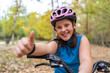 © ADDICTIVE STOCK - Smiling girl showing like gesture while standing near bike