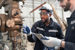© chachamp - Caucasian and Afriacan American engineer man checking with lathe machine at lathe factory