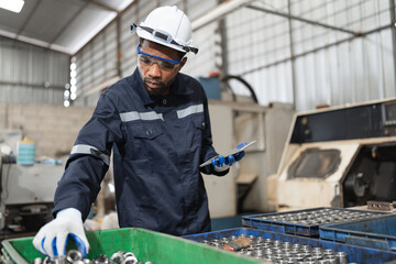 African American engineer man checking spare with tablet computer at spare factory	