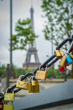 Close Up Of Padlocks On A Chain With The Eiffel Tower In The Background In Paris, France.