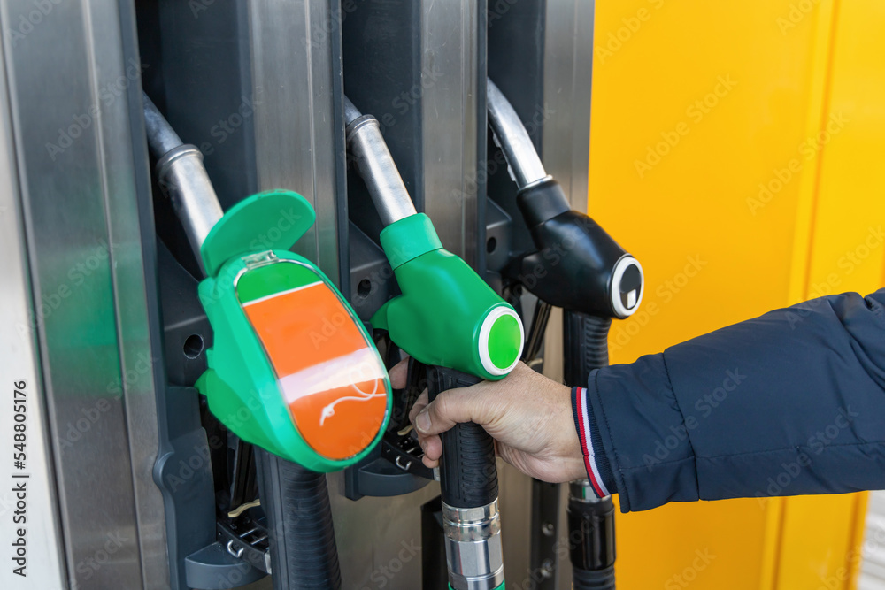 Male hand pumping gas at gas station. Refuel cas at the fuel pump ...
