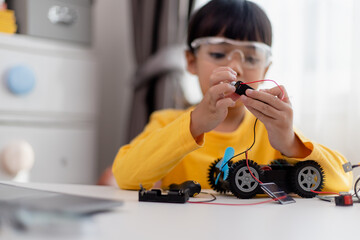 Asia students learn at home in coding robot cars and electronic board cables in STEM, STEAM, mathematics engineering science technology computer code in robotics for kids concept.