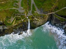 Aerial Of Tintagel Castle View With A Seascape Shore Covered With Grass And Water Making Foam