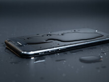 Close-up Of An Old Telephone In Water On A Black Background.