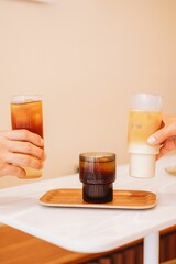 Sticker - Vertical shot of ice latte, cold brew and cold brew tonic on a tray on the white table