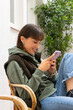 © Anna - Very happy girl. girl with a relaxed position sitting on the chair looking at the mobile with a huge smile on her face