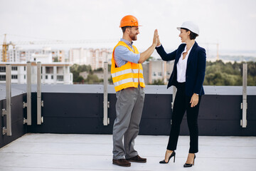 Business woman with architect talking on the roof of the construction building