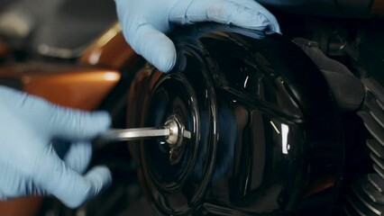 Poster - The mechanic unscrews the cover to replace the air filter in a motorcycle. Close-up. Transport concept