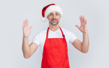 Cheerful Mature Man In Red Waiter Apron And Christmas Santa Hat