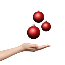 Three Red Baubles Or Christmas Balls Levitating Over Woman's Hand. Hand Palm Up.