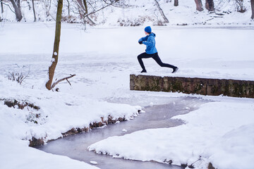 Healthy lifestyle. Young strong man is exercising at snowy park.