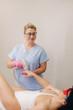 A cosmetologist performs a laser hair removal procedure in the office