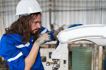 Aufkleber - Factory male engineer worker working with adept robotic arm in workshop. Male engineer maintenance automatic robotic arm machines in factory. Industry robot manufacturing technology