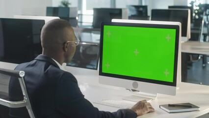 Business African-American Man Working Internet on Computer On Desk. Man Surfing on PC with Green Screen Notebook. Close Up Male Freelancer Searches For Information on The Internet