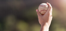 Male Hand Holding Baseball Ball On A Background Stadium