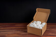 © RooM The Agency - Open cardboard box filled with packing foam on a table