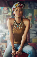Wall Mural - Portrait, fashion and heritage with a black woman on a stool indoors with an African style turban. Model, culture and tradition with an attractive young female feeling empowerment or proud