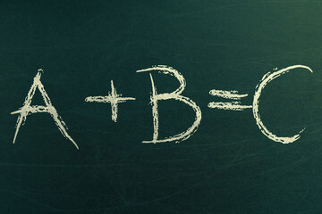 Math formula with variables A plus B equals C. Mathematics learning and school formulas. Handwritten on chalkboard