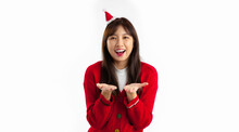 Young Asian Woman In Red Sweater Wearing Santa Hat Headband Smiling Hands Pointing To You White Background. Merry Christmas.