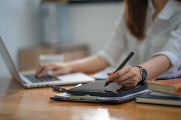 Leinwandbilder - Closeup hand signing or using a digital pen on a computer tablet on the desk, a businesswoman use a stylus pen to write on a tablet