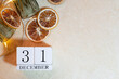 calendar with the date December 31 on a background of oranges, glasses of garland on a beige background. decor christmas