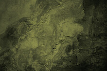 Brown Green Old Concrete Wall Surface. Dark Olive Color. Close-up. Rough Background For Design. Distressed, Cracked, Broken, Crumbled.