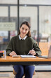 © David - Cheerful Asian business woman work in workspace office. do math finance on wooden desk in office, tax, accounting, financial concept.