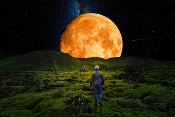 Wall Mural - lonely man walking up the mountain towards a cabin