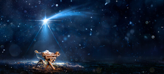 nativity scene - birth of jesus christ with manger in snowy night and starry sky - abstract defocuse