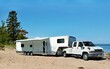 © dvande - White toy hauler travel trailer camping on the sandy shore of lake Superior