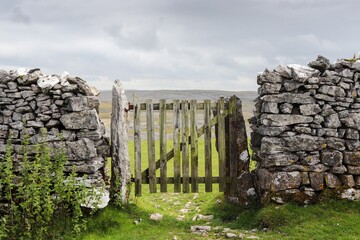 Sticker - Closeup of a stone and wood gate in a field in the countryside of Yorkshire, England