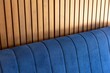 Blue sofa against modern and elegant wooden wall
