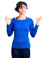 Poster - Beautiful young woman with short hair wearing training workout clothes relaxed and smiling with eyes closed doing meditation gesture with fingers. yoga concept.