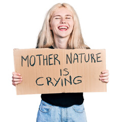 Poster - Young caucasian woman holding mother nature is crying protest cardboard banner smiling and laughing hard out loud because funny crazy joke.