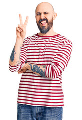 Poster - Young handsome man wearing casual clothes smiling with happy face winking at the camera doing victory sign. number two.