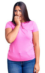 Sticker - Young beautiful brunette woman wearing casual t-shirt looking stressed and nervous with hands on mouth biting nails. anxiety problem.