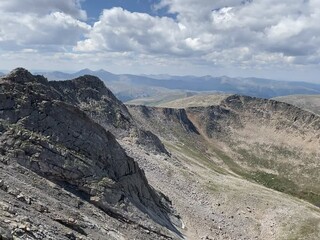 Canvas Print - Aerial view of a mountain range and Mount Evans with a glacial lake in Colorado on a sunny day