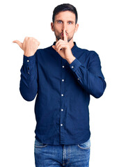 Poster - Young handsome man wearing casual shirt asking to be quiet with finger on lips pointing with hand to the side. silence and secret concept.