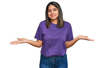 Sticker - Young hispanic girl wearing casual purple t shirt clueless and confused expression with arms and hands raised. doubt concept.